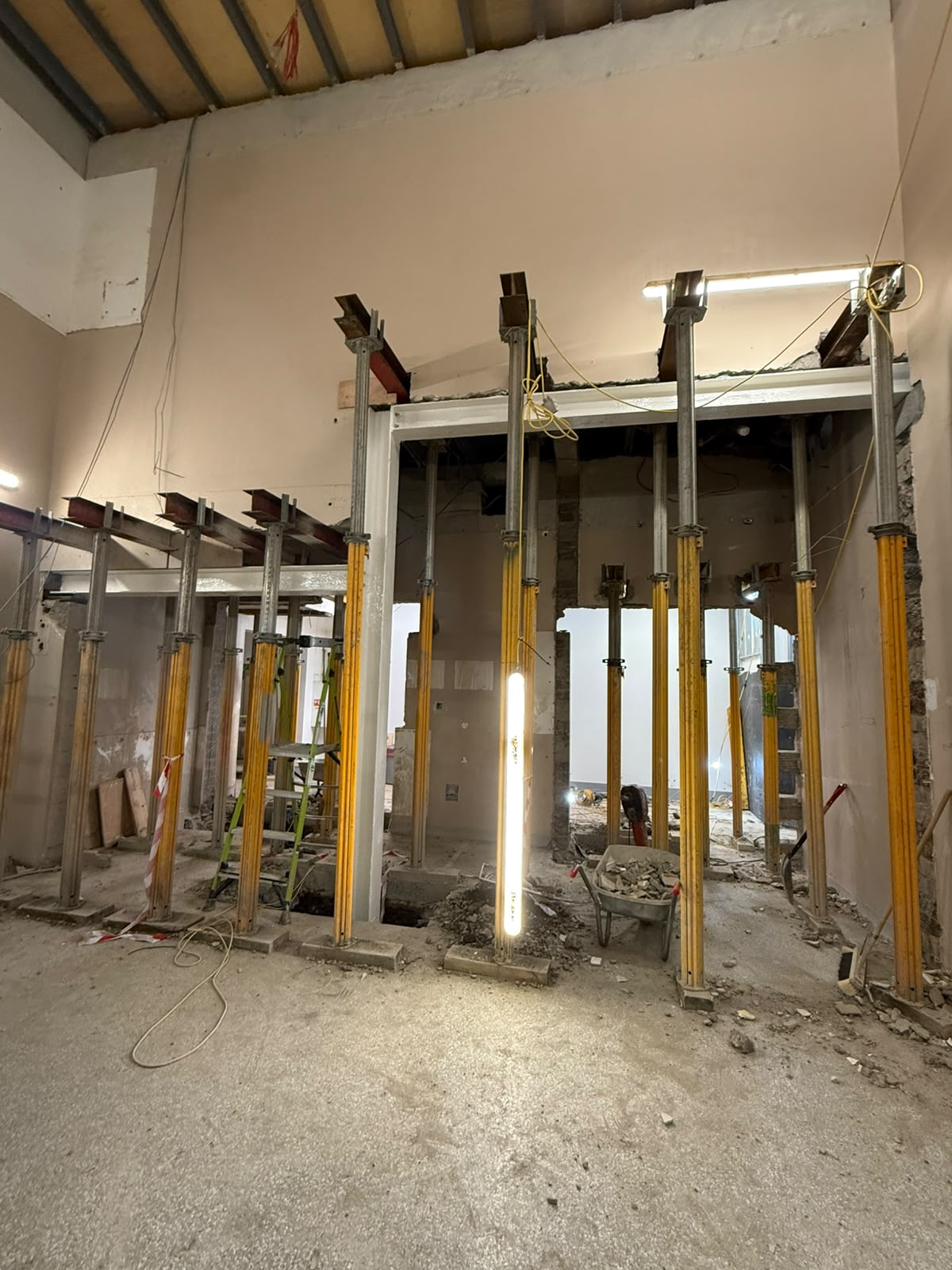 Rows of adjustable props and steel beams supporting openings through internal walls