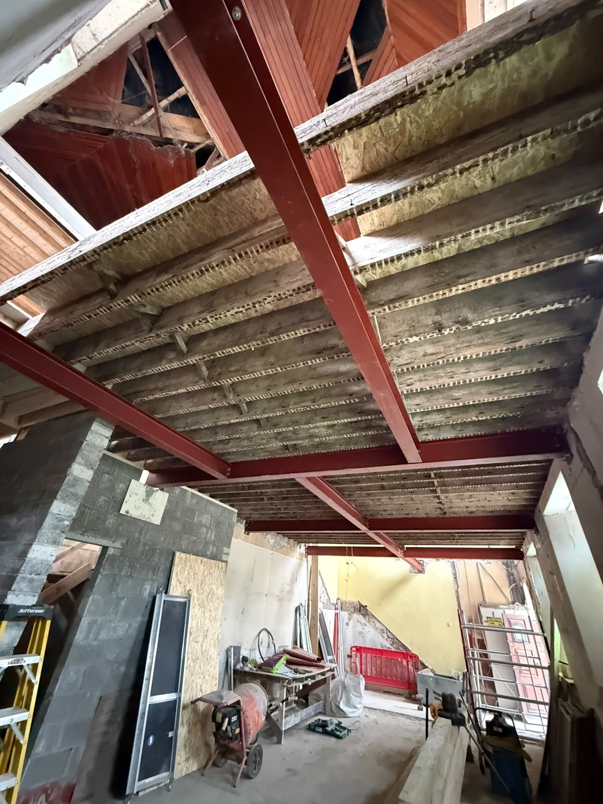 Steel beams and posts supporting original floor joists in a renovated period building