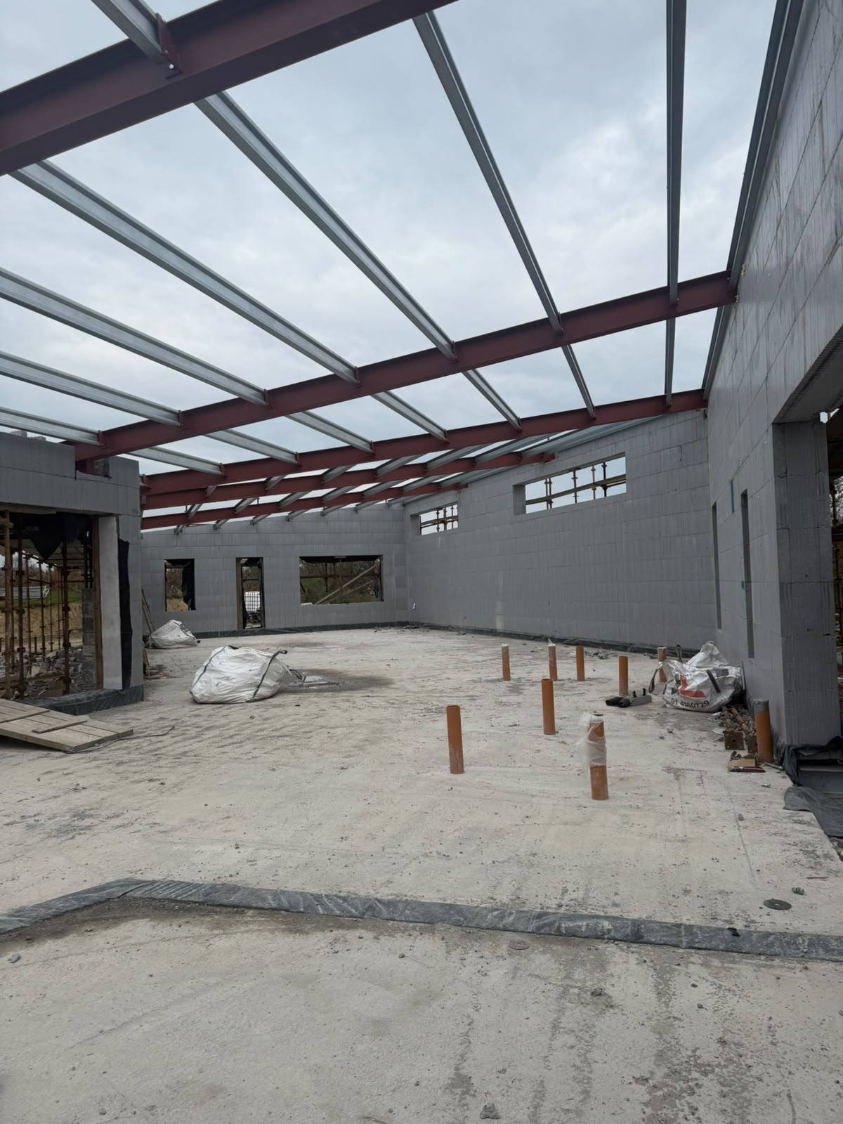 Painted steel portal frame with galvanised purlins erected over blockwork on a commercial building