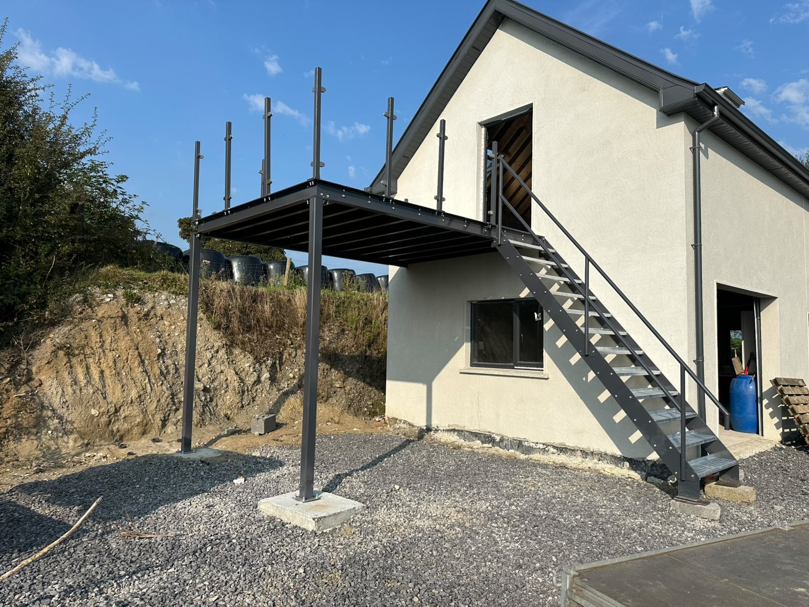 Fabricated steel staircase with mesh treads and steel balustrade leading to a warehouse mezzanine