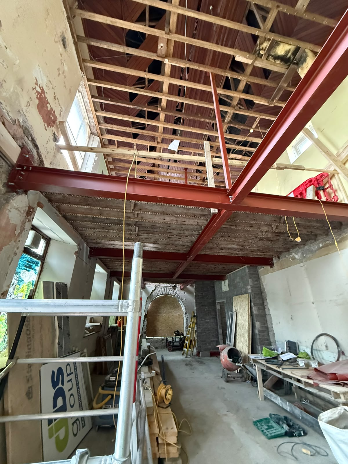Red oxide painted steel beams installed at ceiling and roof level inside a period house being renovated