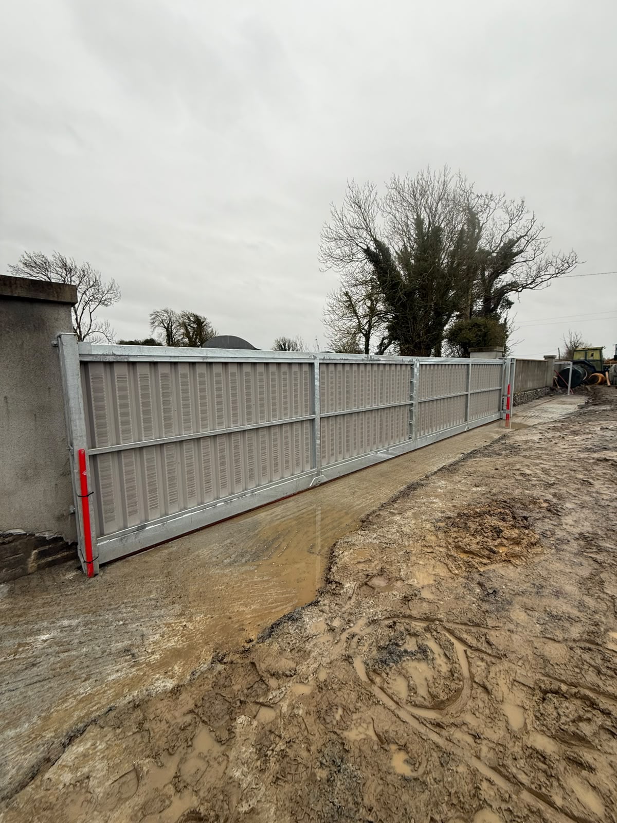 Galvanised clad entrance gates seen from the yard side with hinge posts and drop bolts